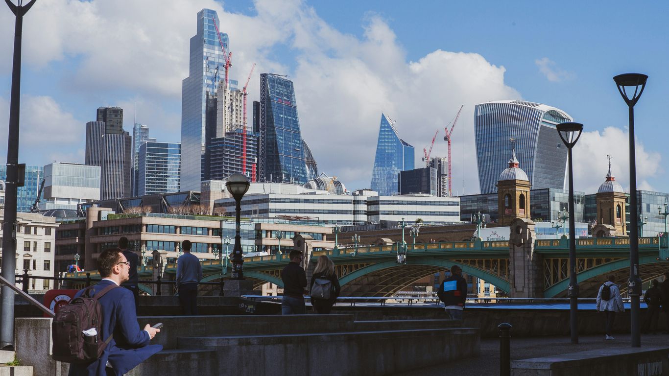 a woman standing on a bridge looking at her cell phone