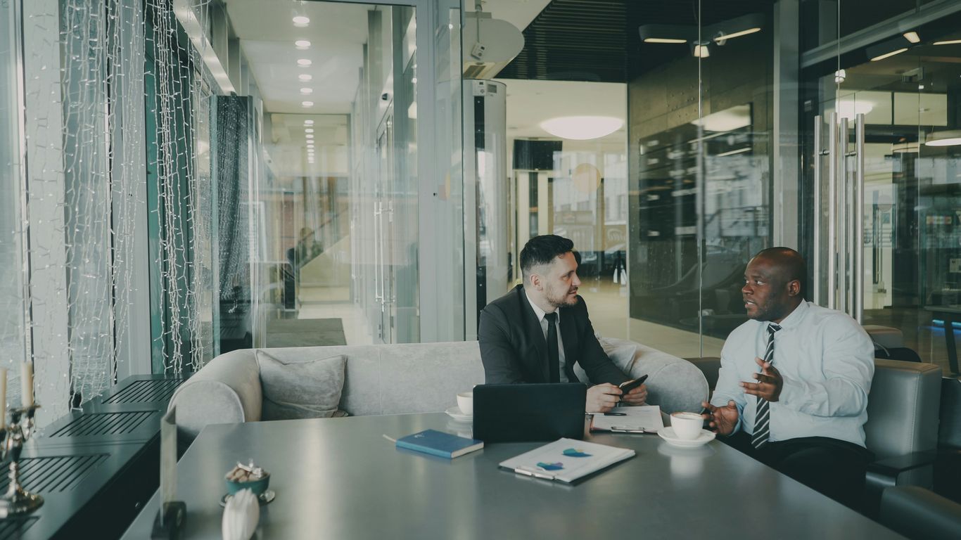 Two businessmen talking at a table