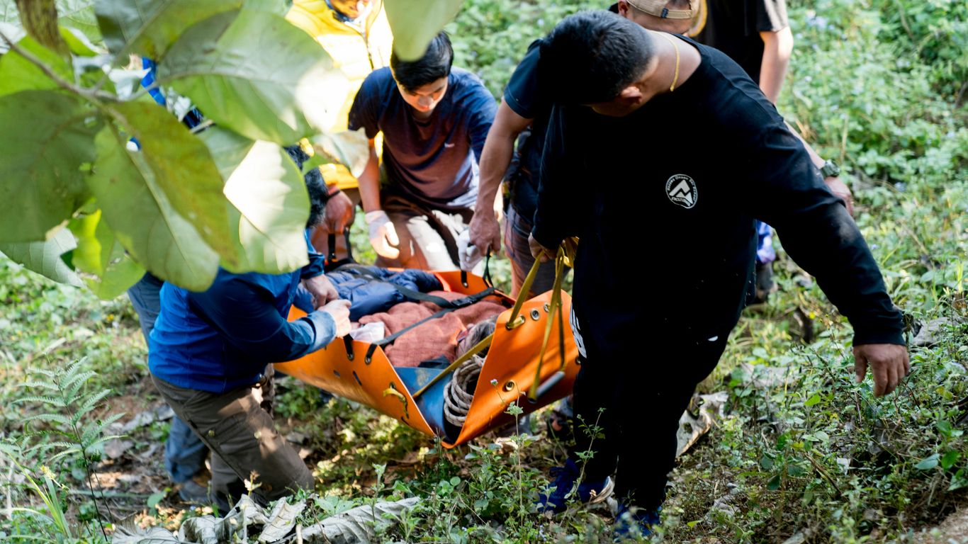 A group of people standing around a man on a stretcher