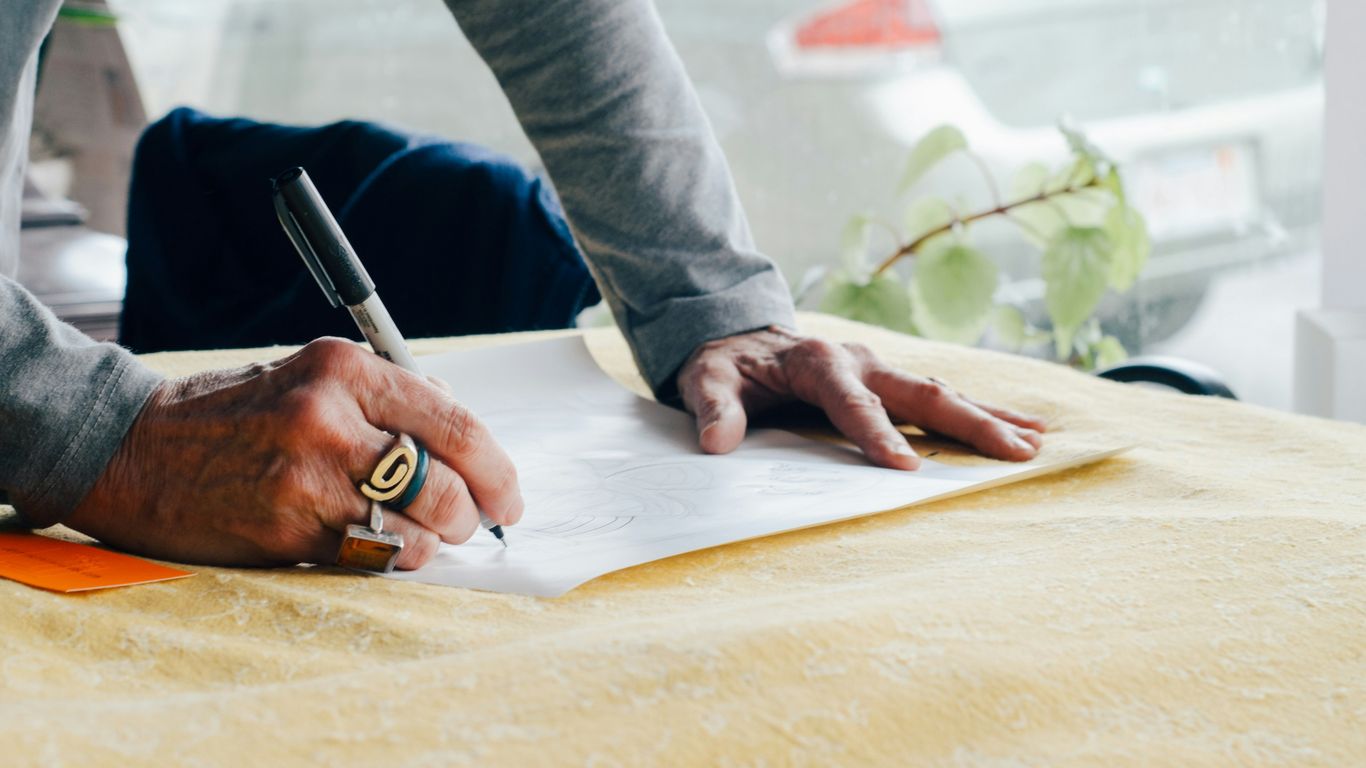 person writing on white plain paper on the table photography