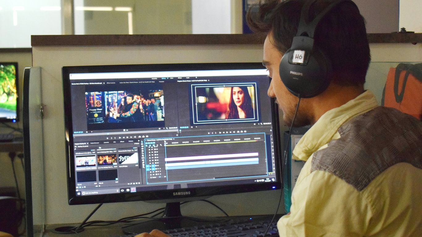 a man sitting in front of a computer with headphones on