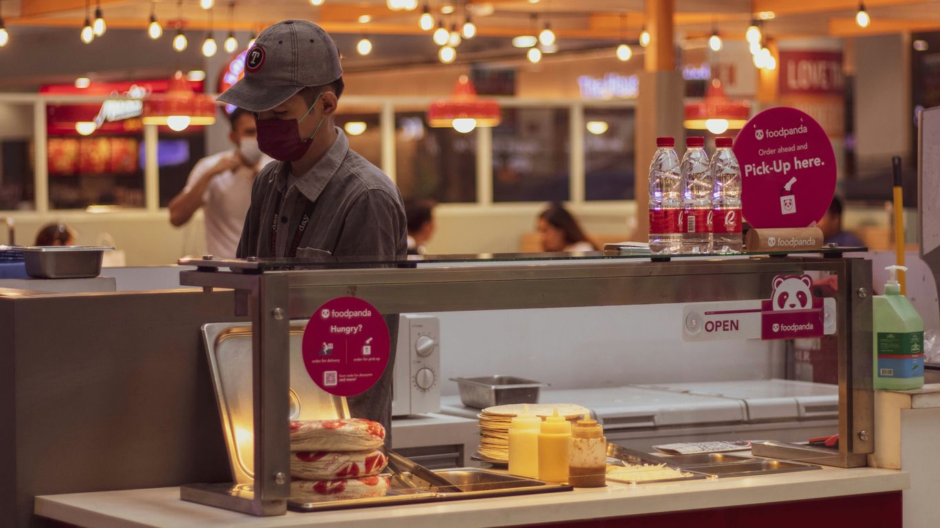 a man standing behind a counter in a fast food restaurant
