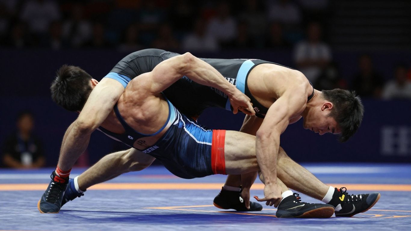 Luptători olimpici în acțiune pe saltea.