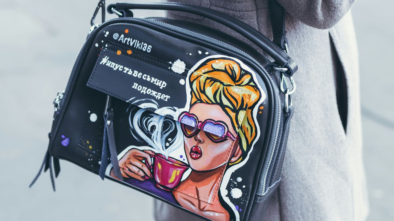 person with black leather cross body bag