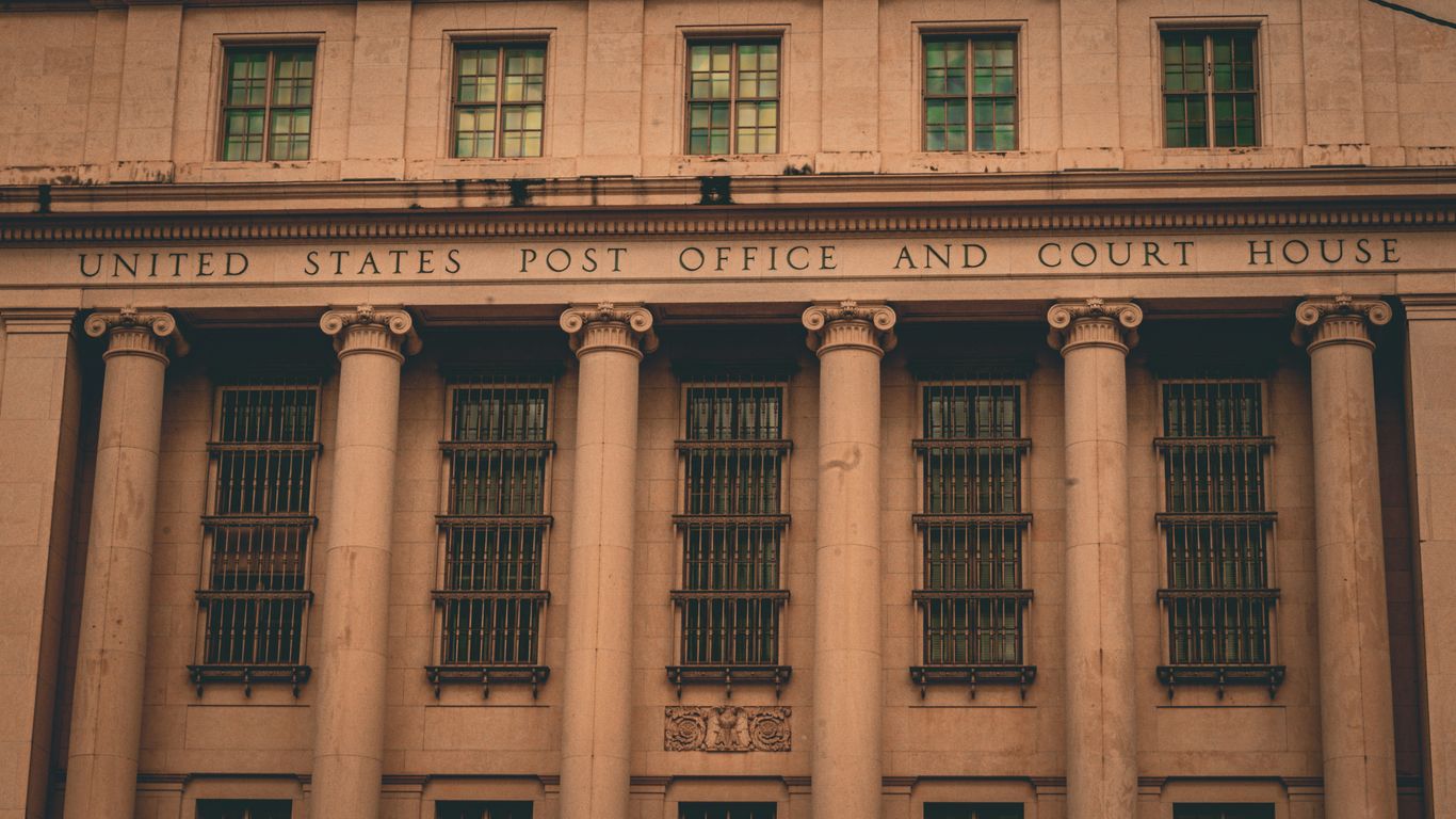 A large building with columns and a clock on the front of it