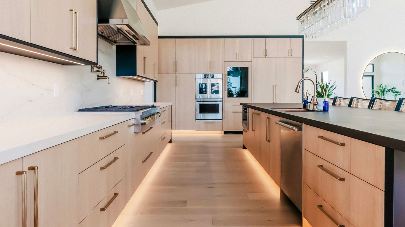 Modern kitchen with light wood cabinets and island.