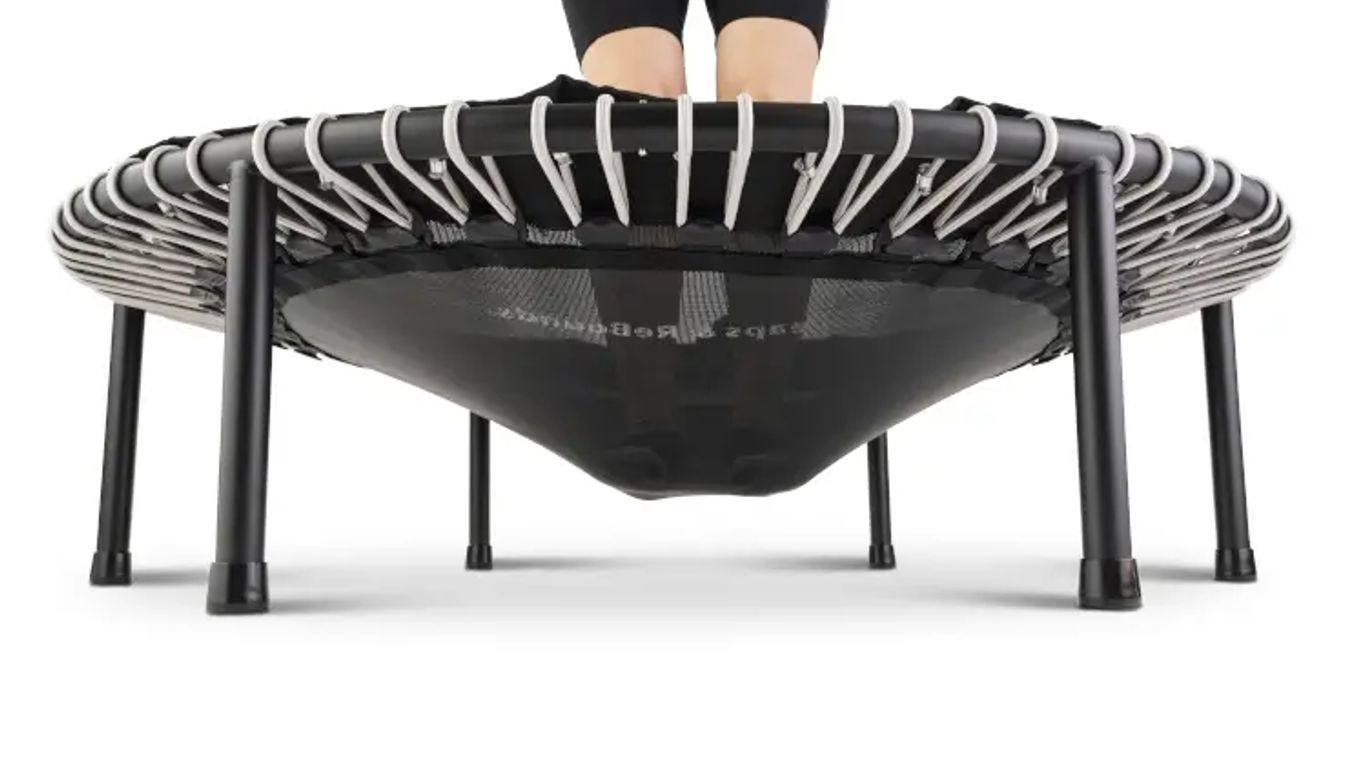Person standing on a mini trampoline, viewed from below.