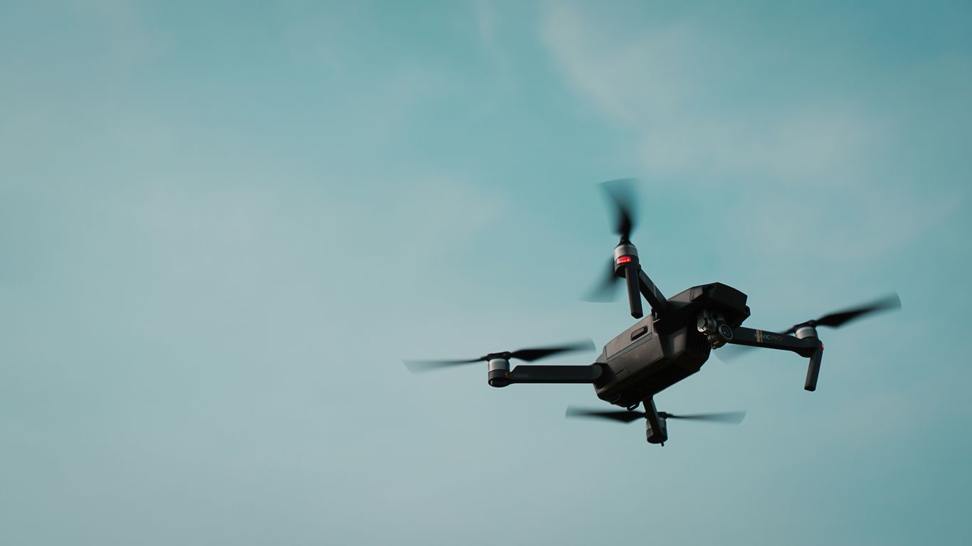 A futuristic military drone patrolling in dark lighting