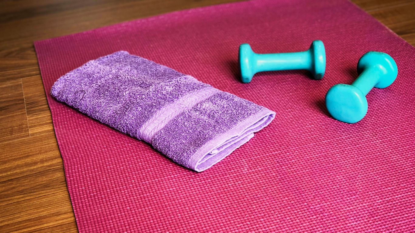 Cushioned yoga mat beside folded blanket