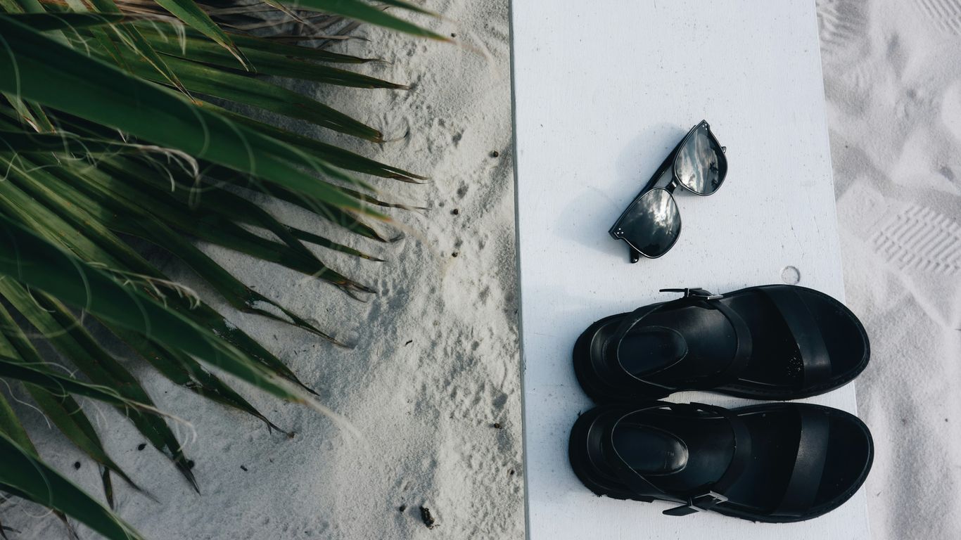 A minimalist folded mat sits near a pair of sandals