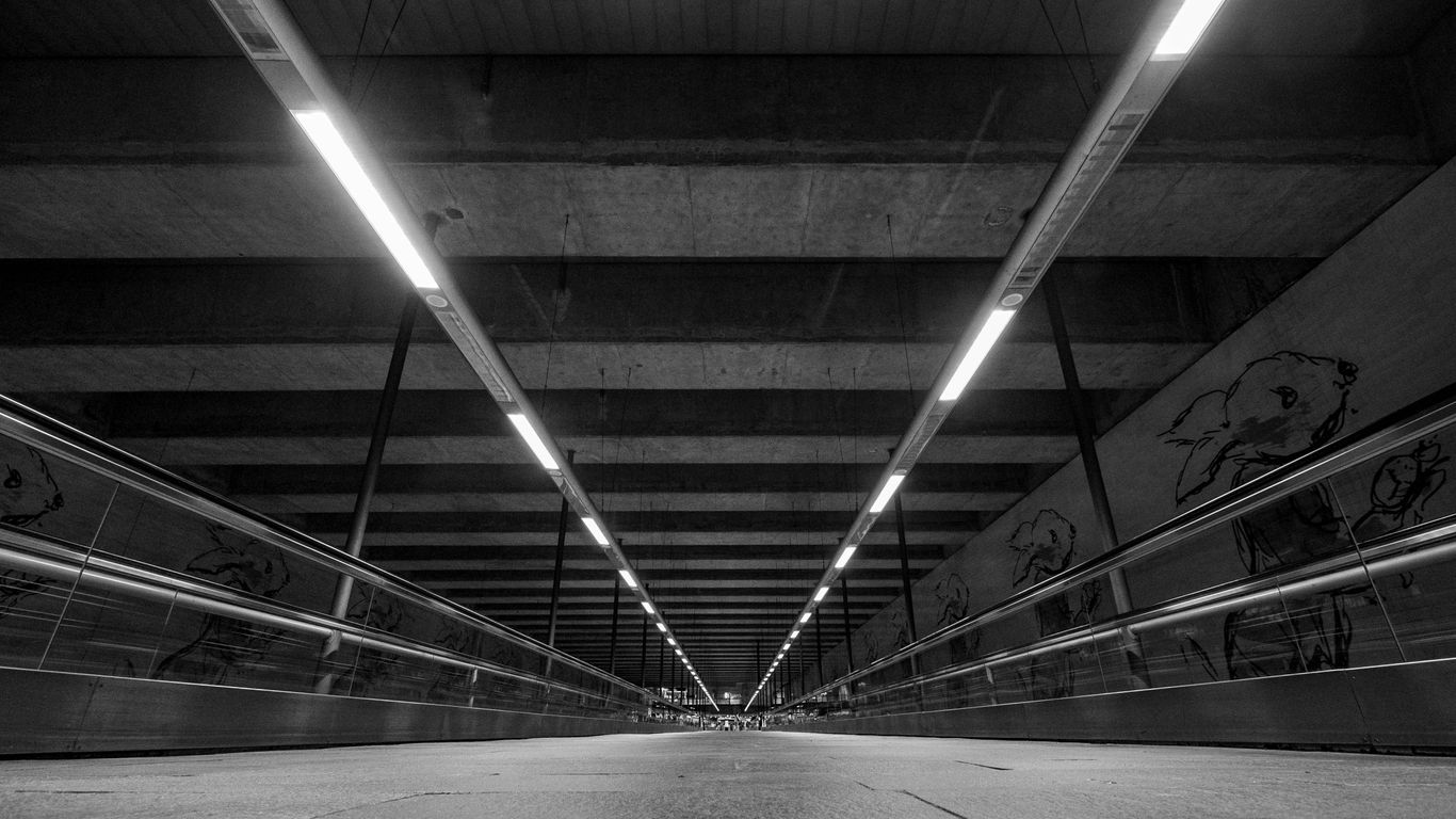 a black and white photo of a staircase with a railing and a light