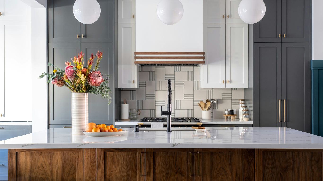 a kitchen with a marble counter top and wooden cabinets