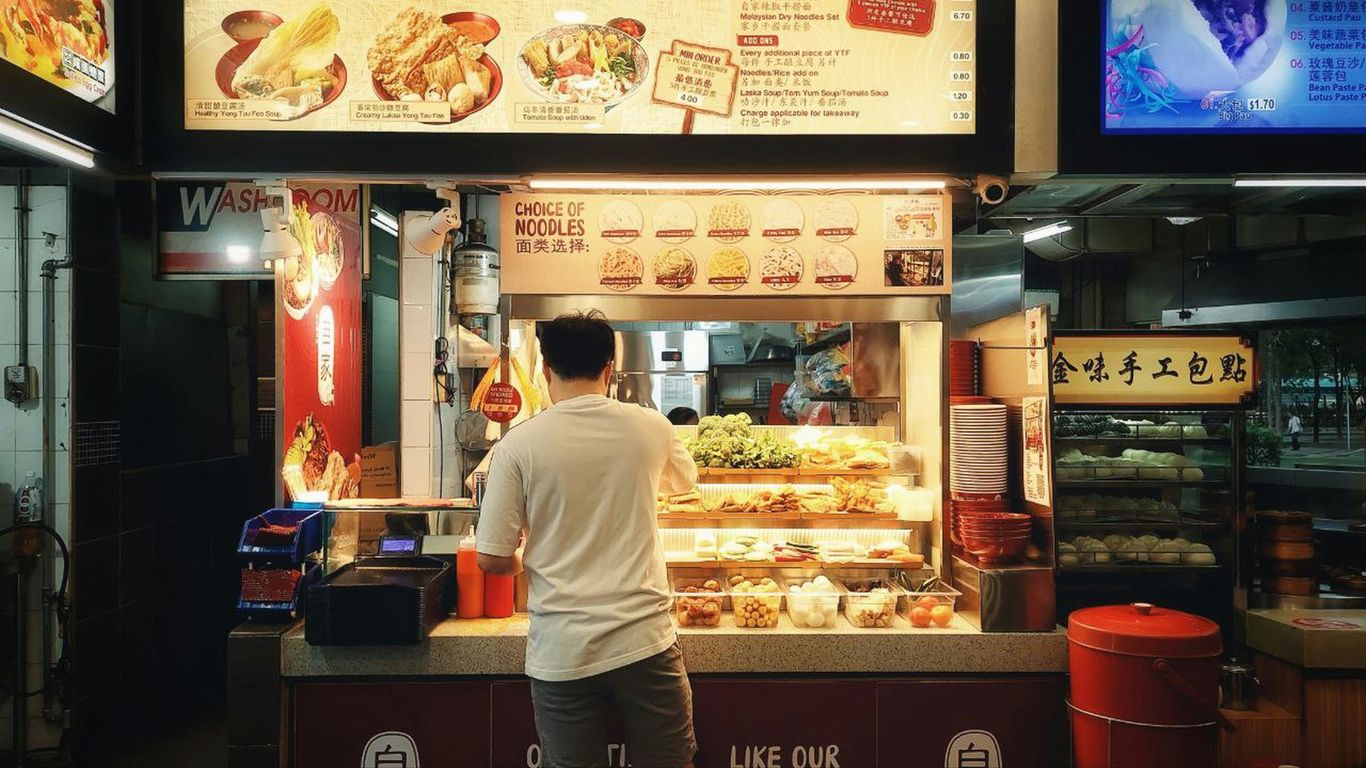 Customer enjoying a famous hawker meal at sunset