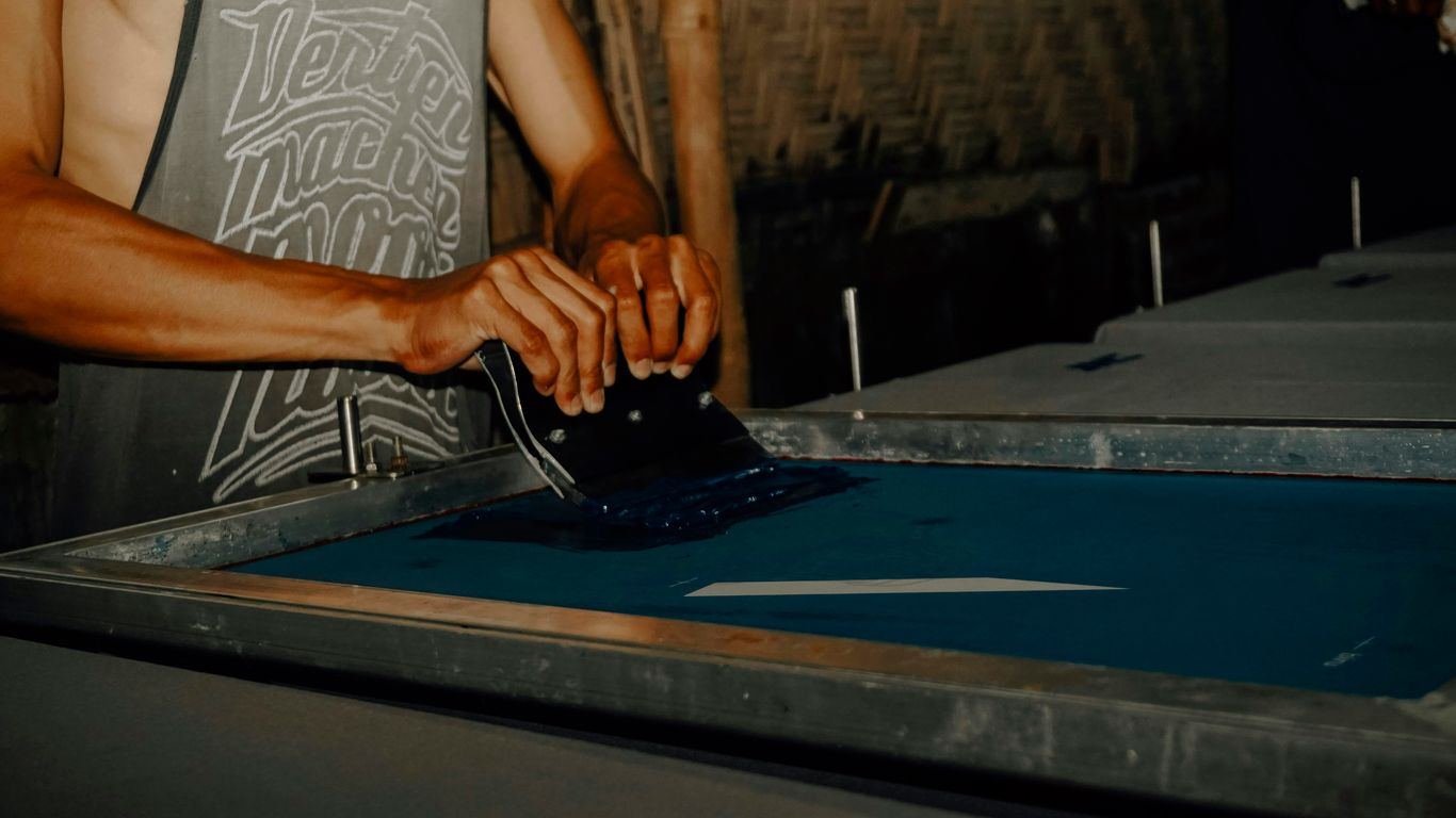 man in white tank top standing beside blue and silver table