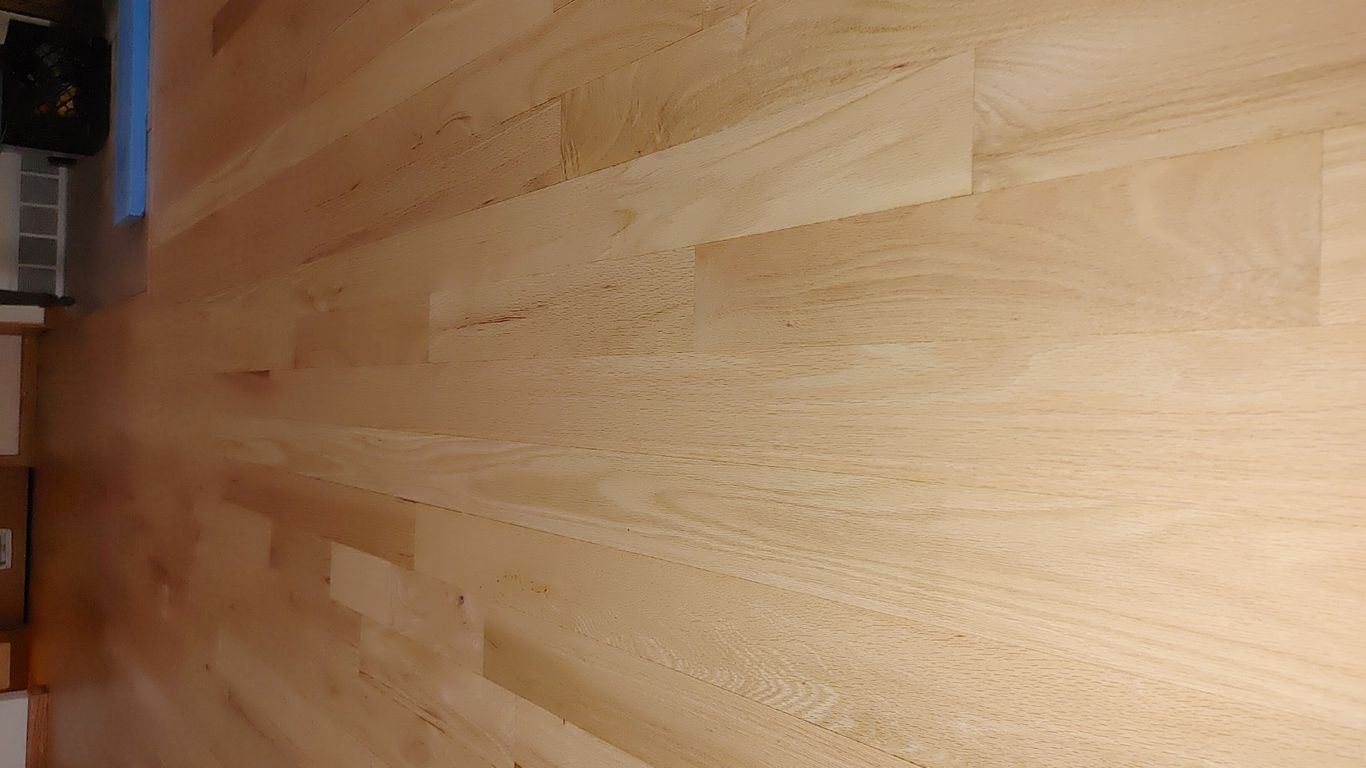 A polished wooden floor in a spacious interior setting.