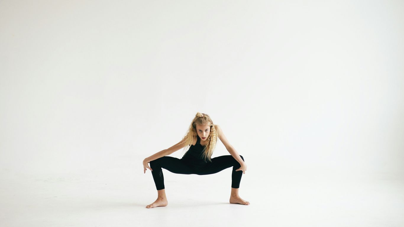 A woman in black activewear performs a yoga pose.