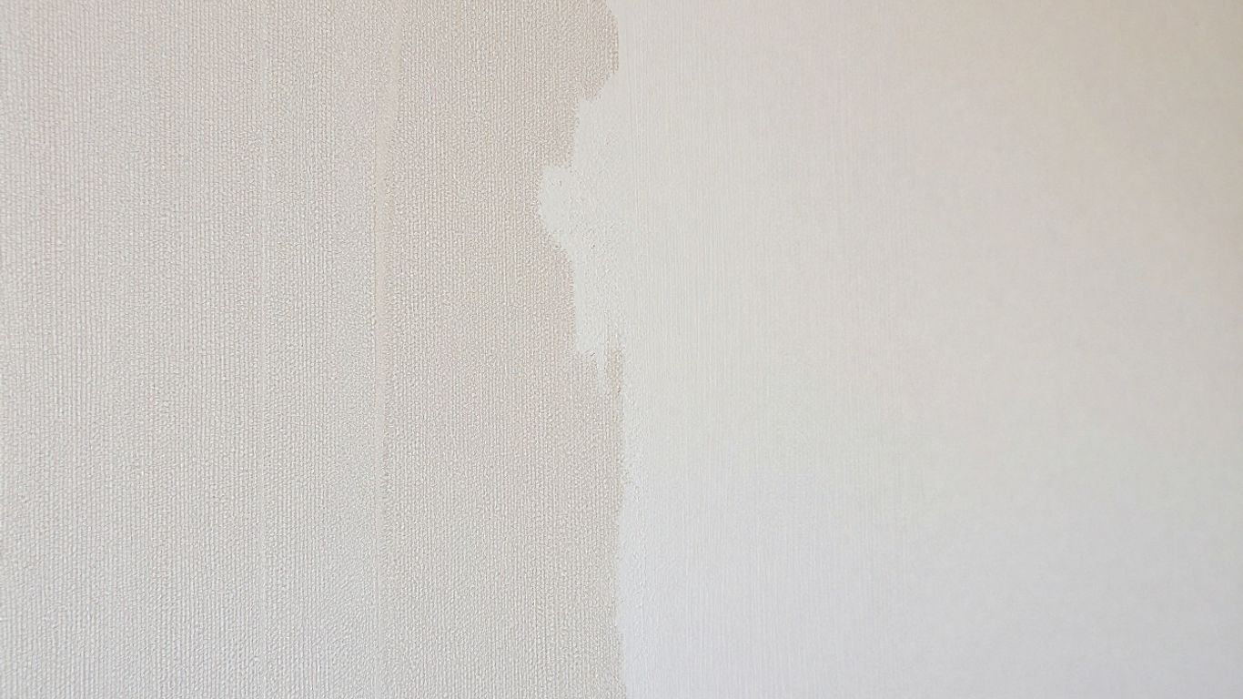 Wall with wallpaper and plaster sections.