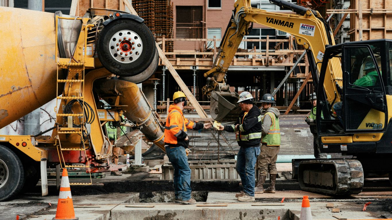 a couple of men standing next to a construction site