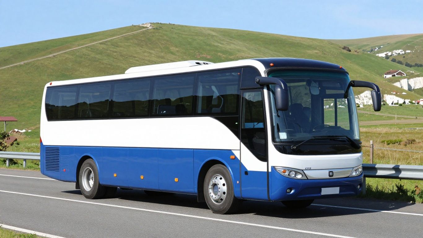 Coach bus travelling on a road towards white cliffs.