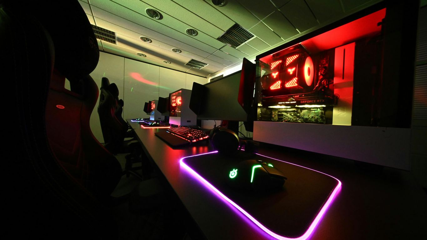 a computer desk with neon lights in a dark room