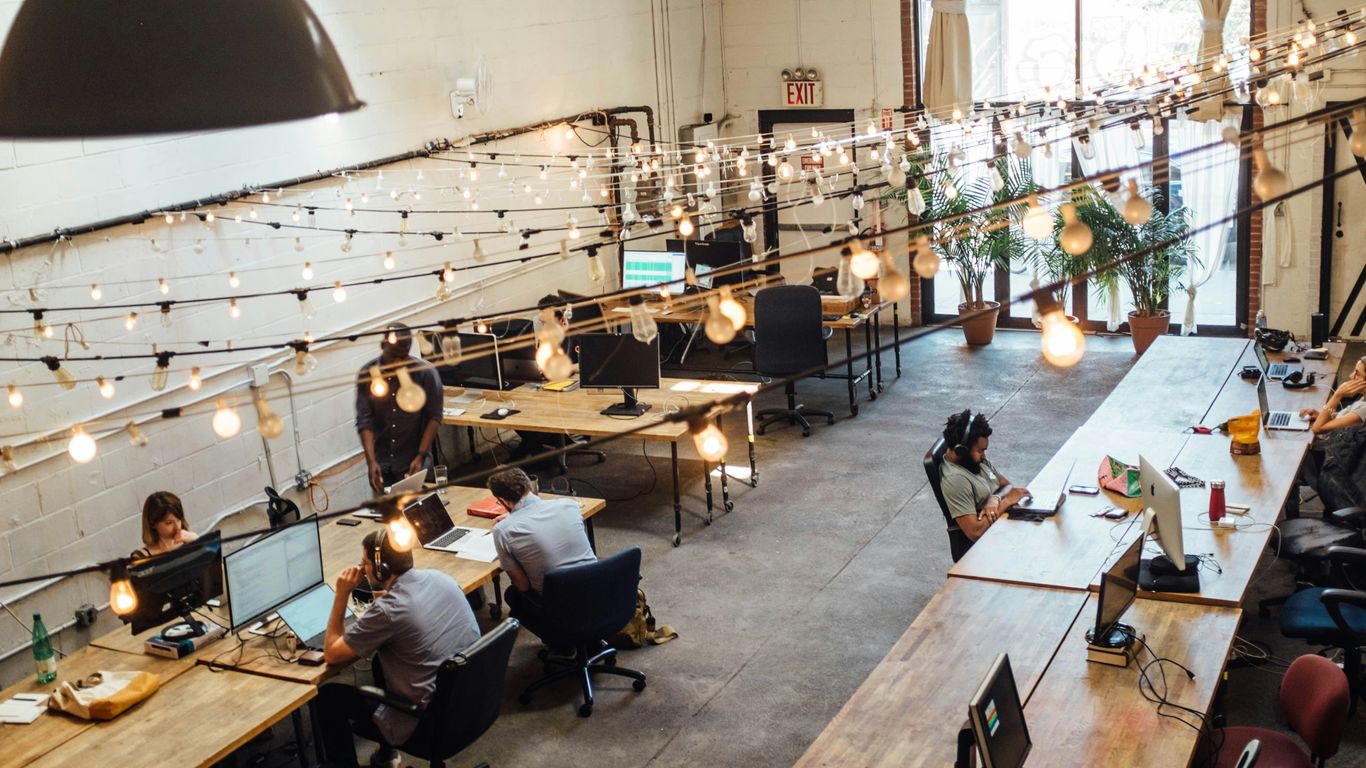 Pessoas utilizando dispositivos em espaço de coworking