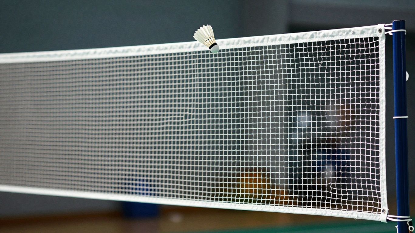 Badminton net height with shuttlecock in flight.