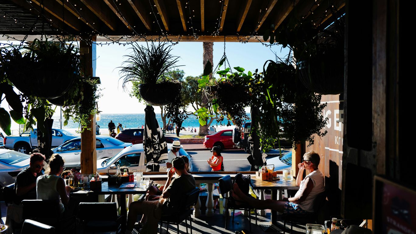 People dining at an outdoor cafe with ocean view