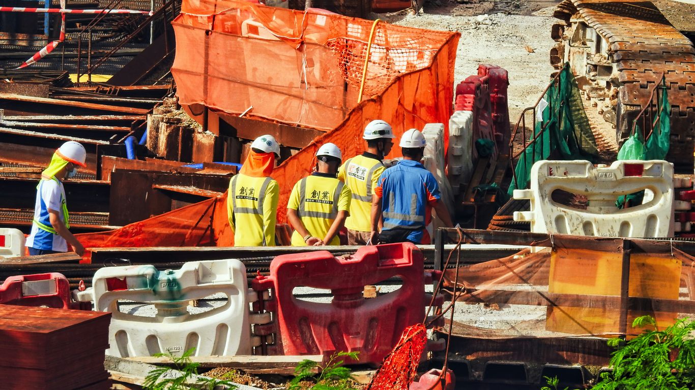 a group of men in hardhats working on a construction site