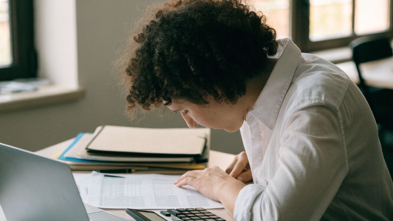 Bookkeeper reviewing transaction records at desk