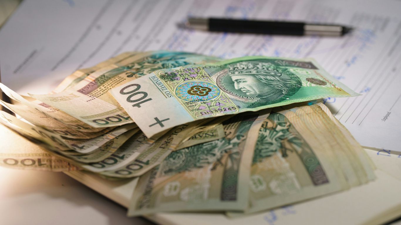 Stack of polish currency banknotes on papers.