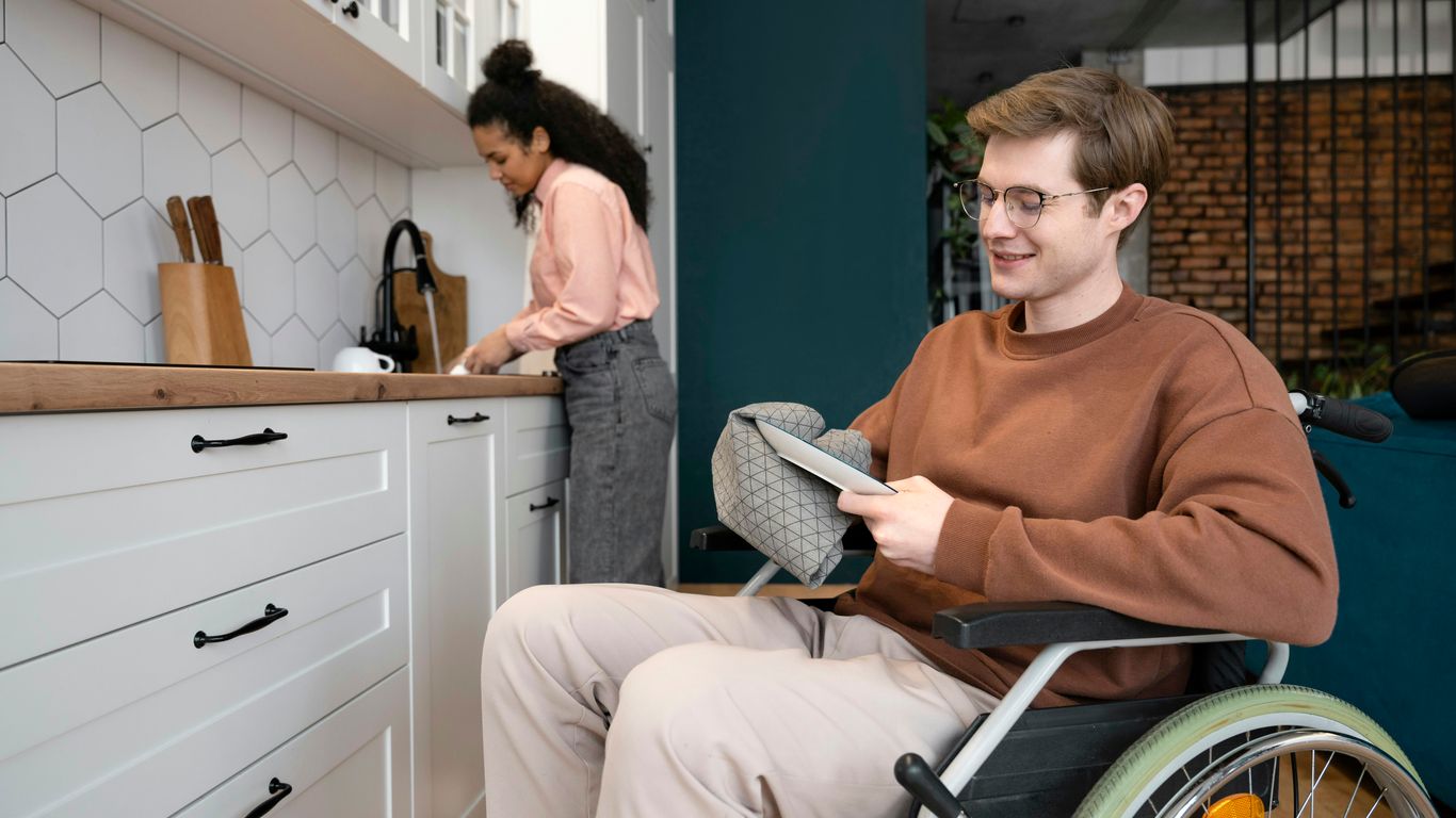A man in a wheel chair in a kitchen