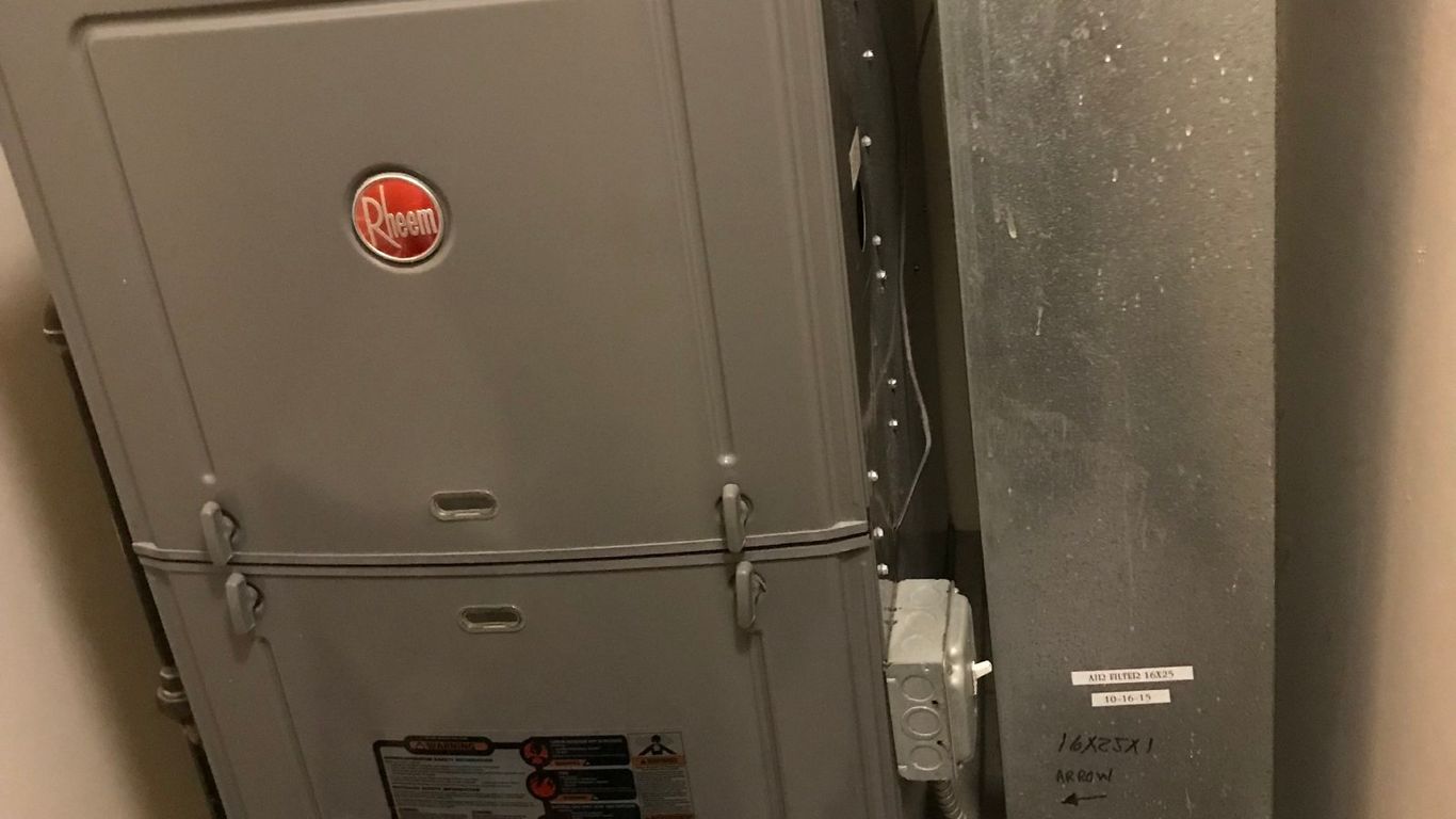 A Rheem furnace and air duct system in a utility closet.