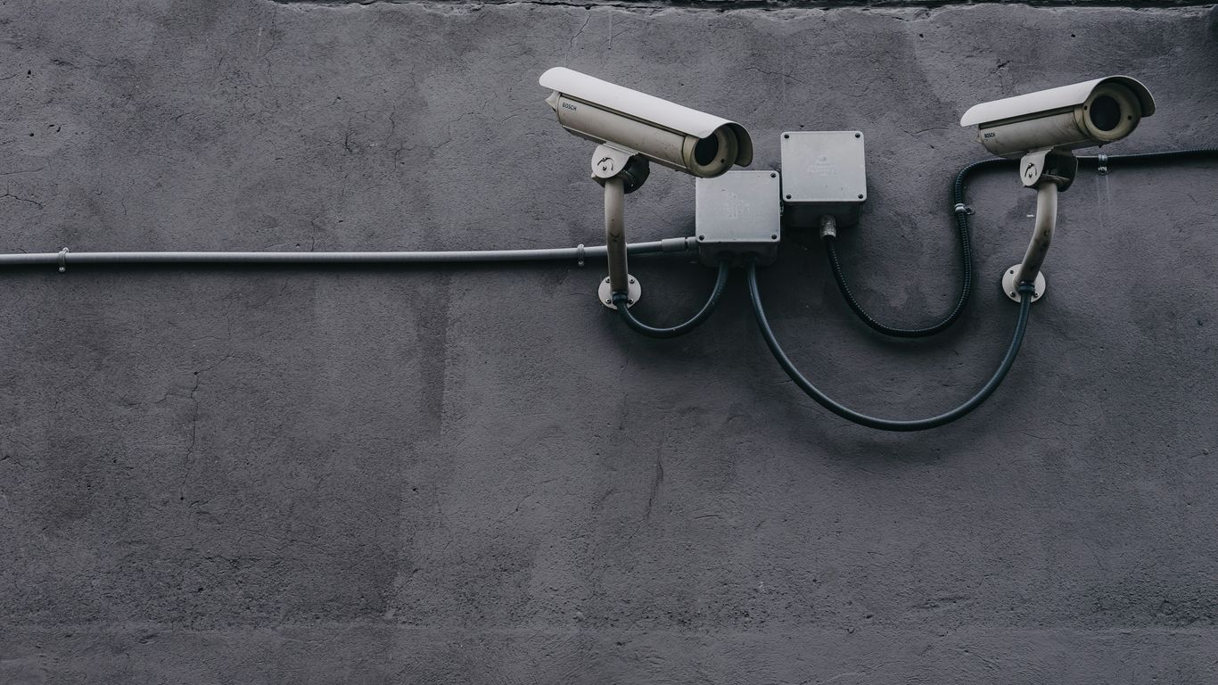 two bullet surveillance cameras attached on wall