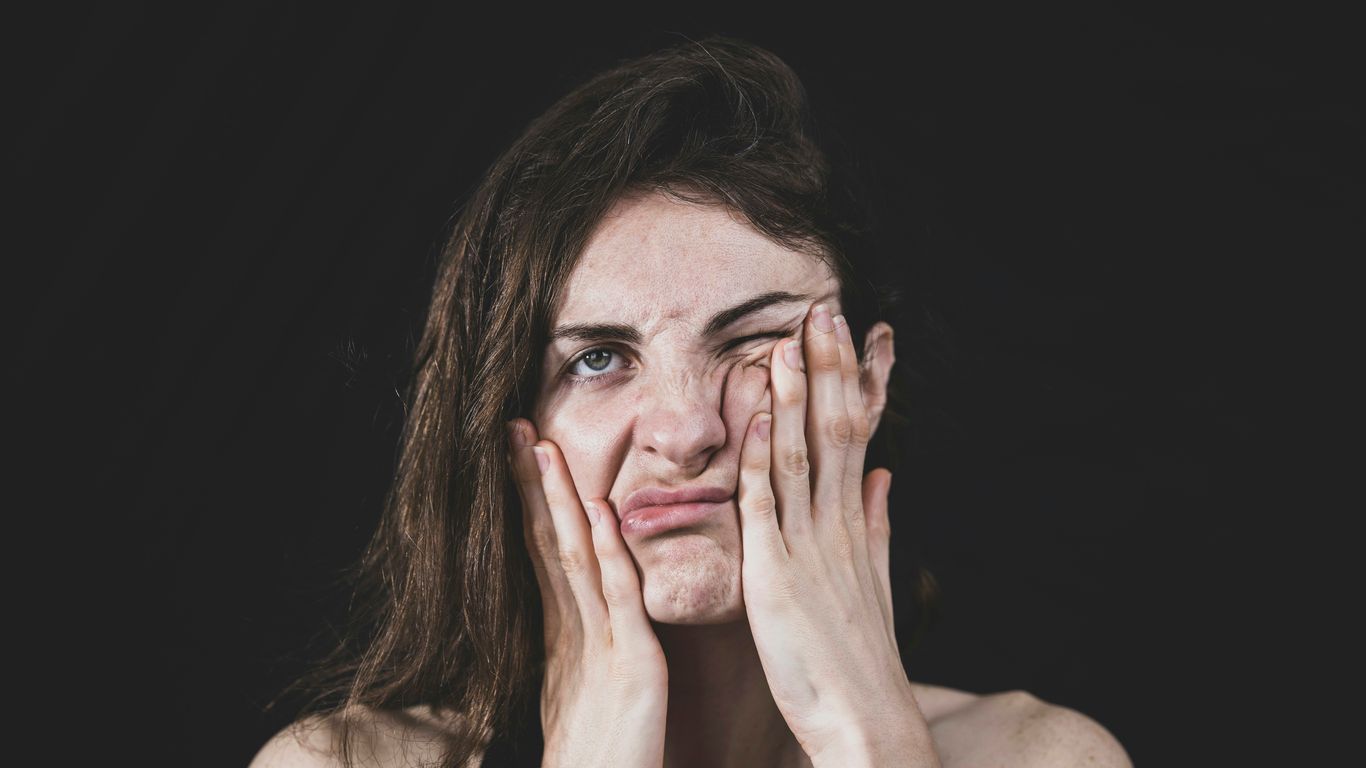 woman covering her face with her hand
