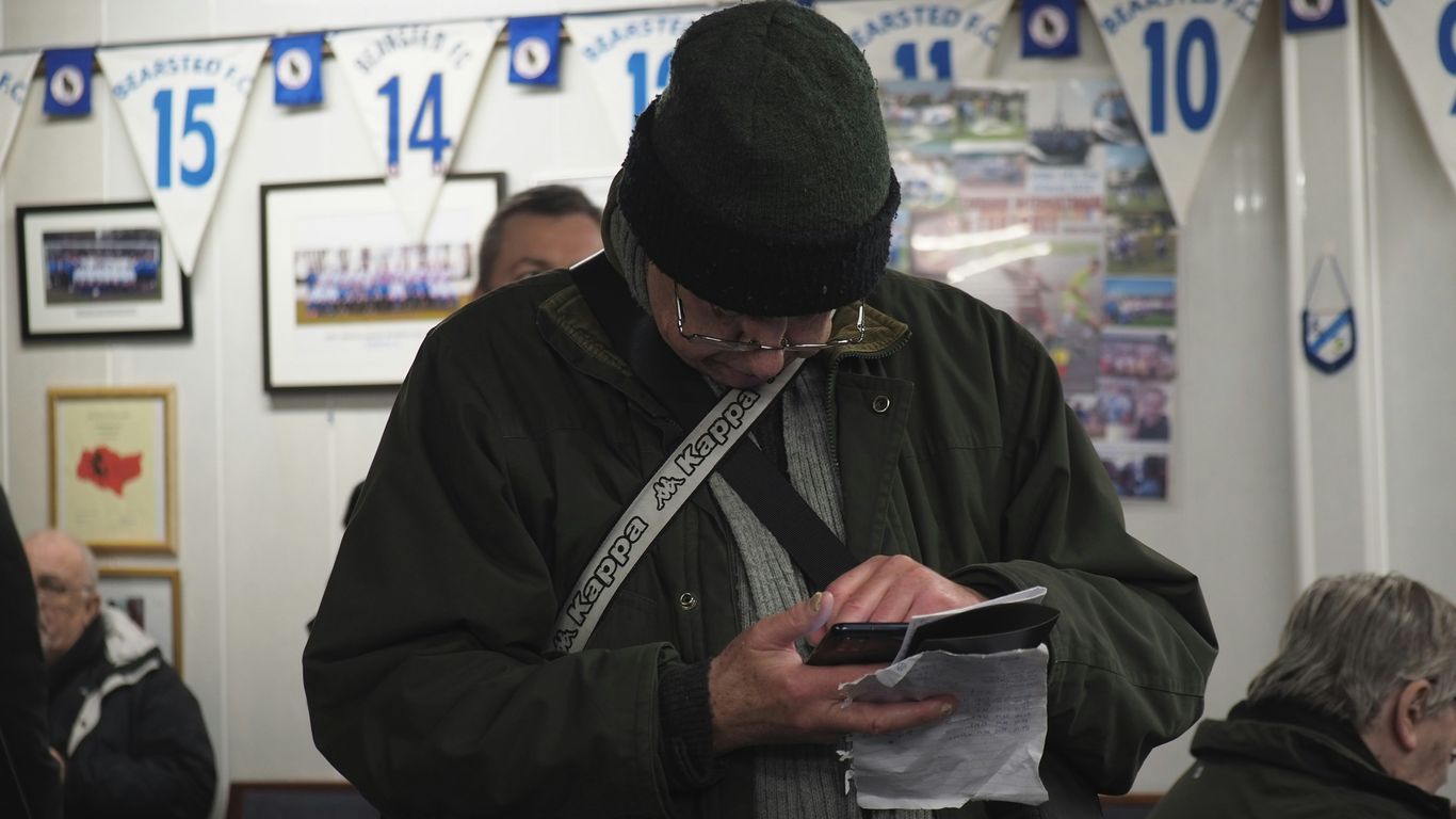 a man standing in a room looking at a piece of paper