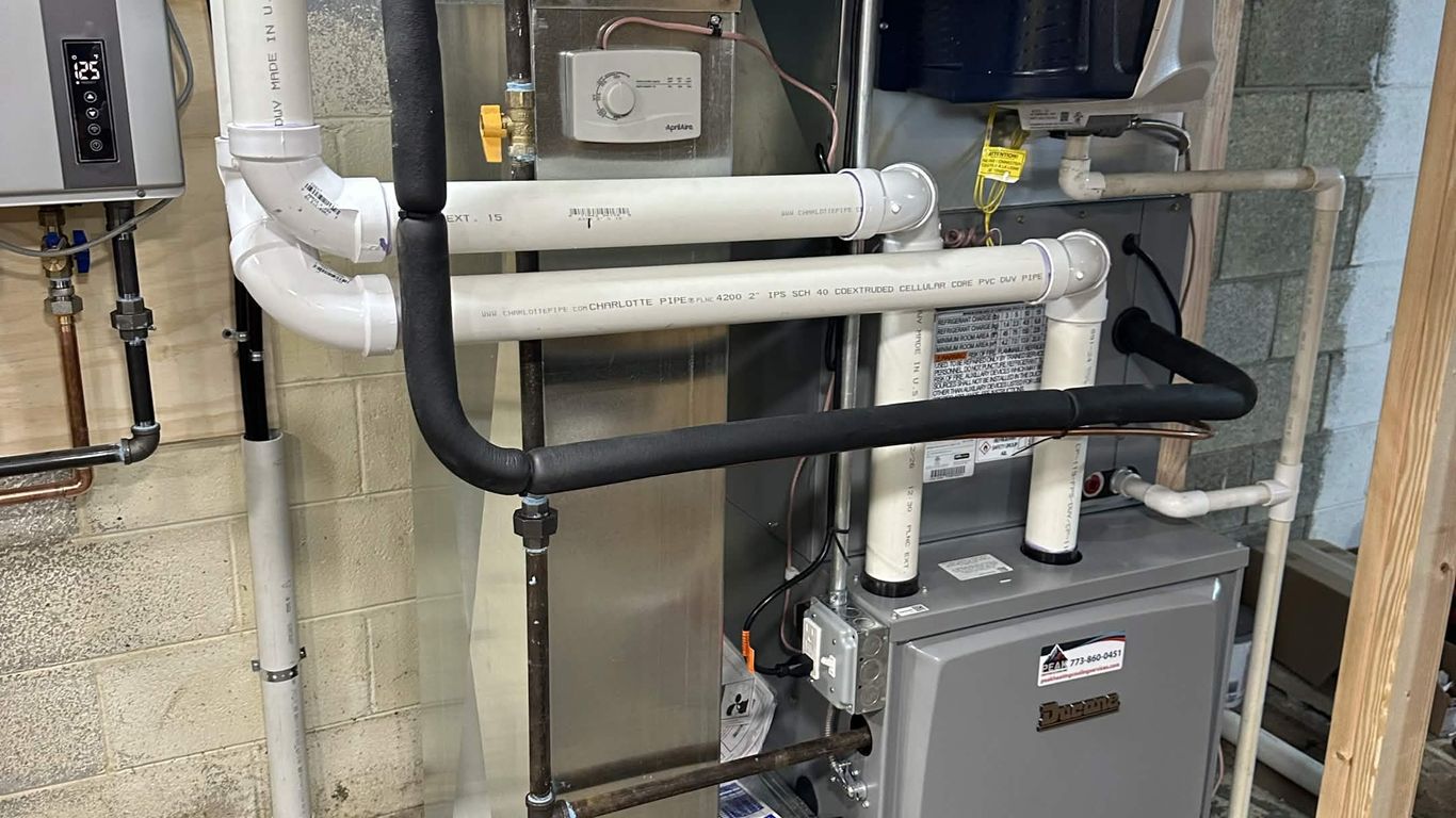 Furnace and water heater installation with pipes and ductwork.