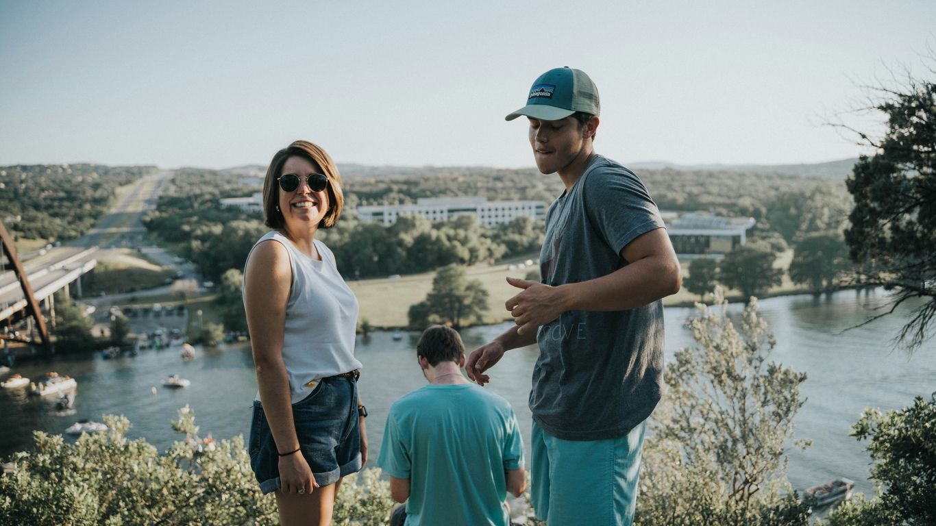 woman and men on cliff facing river