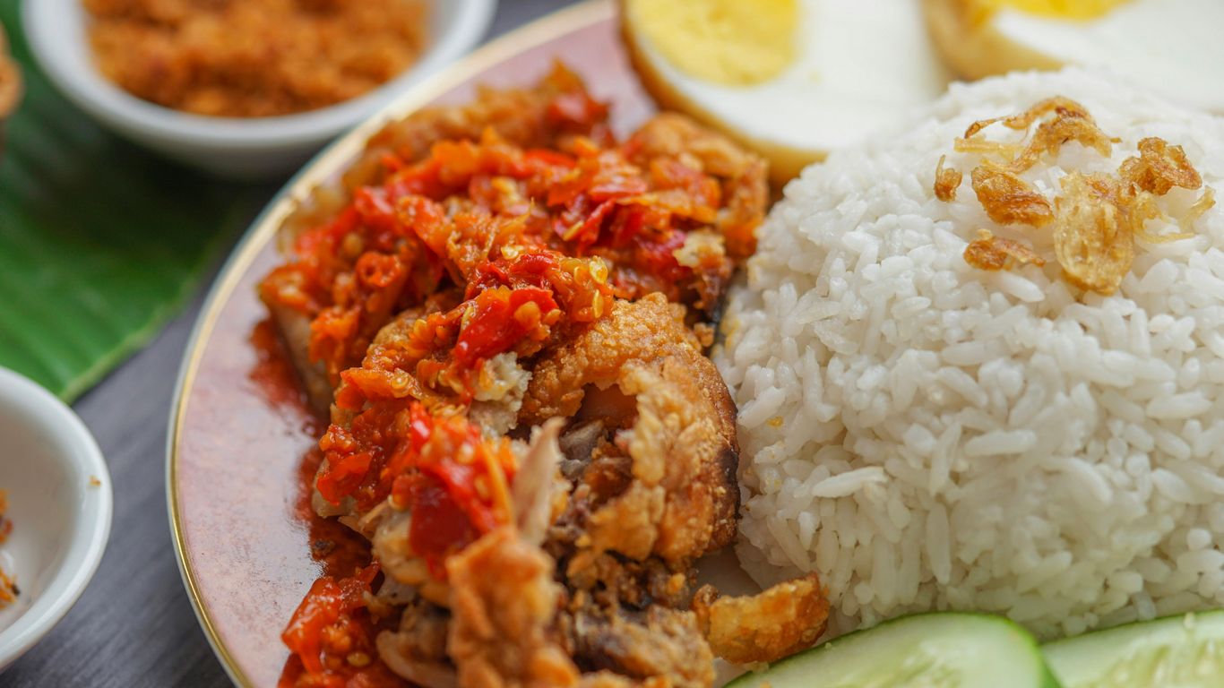 rice and fried meat with egg in plate