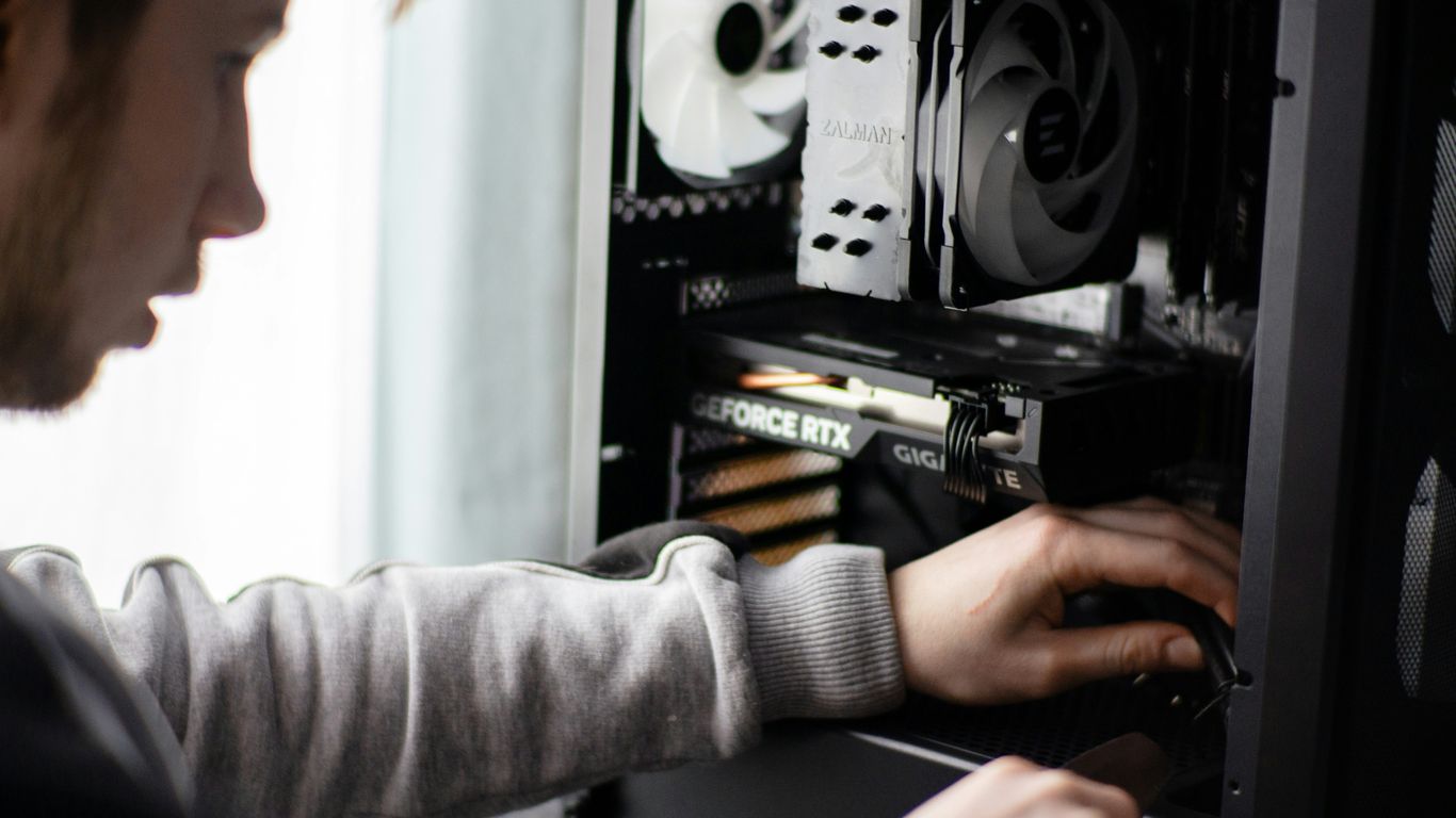 A man is working on a computer in a room