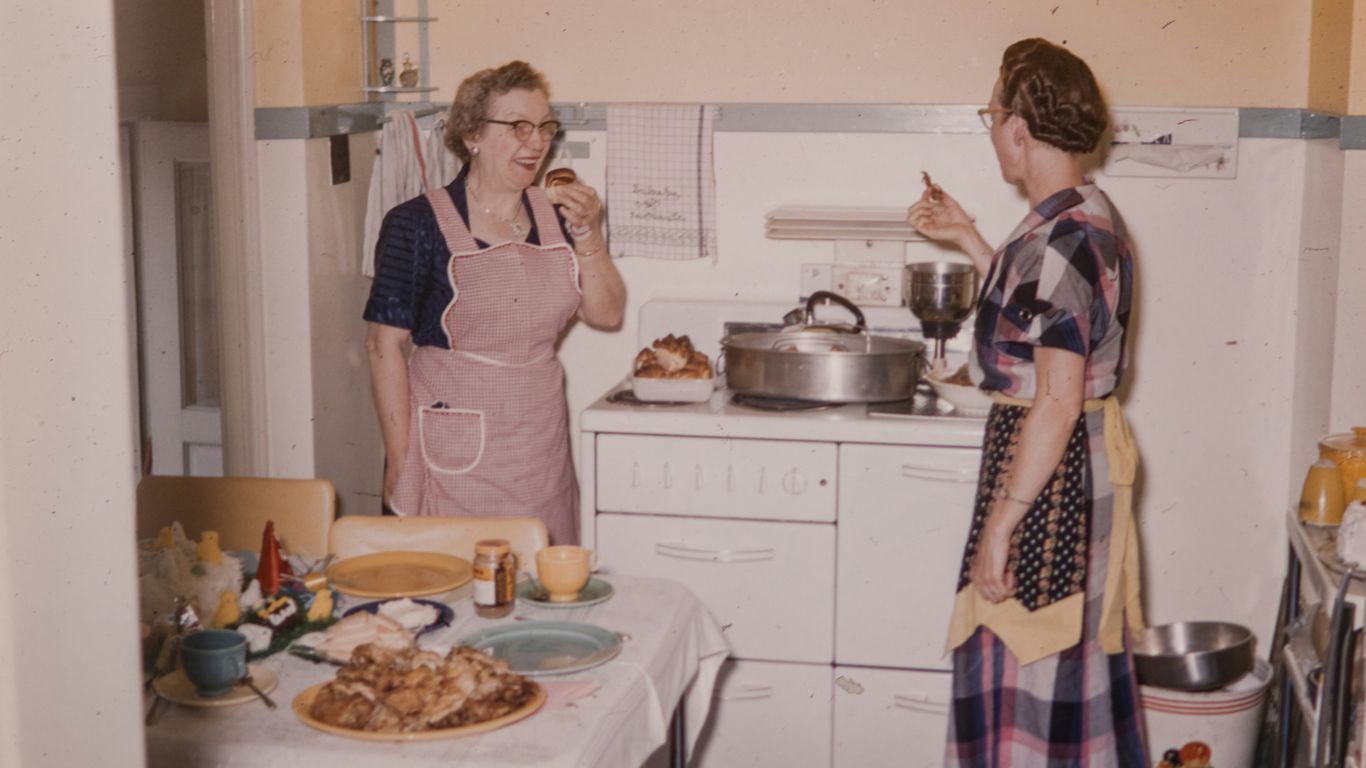 a couple of women standing in a kitchen