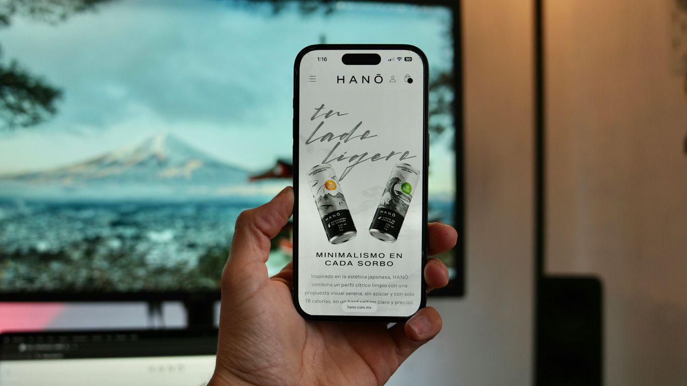 Hand holding smartphone displaying website with drinks.