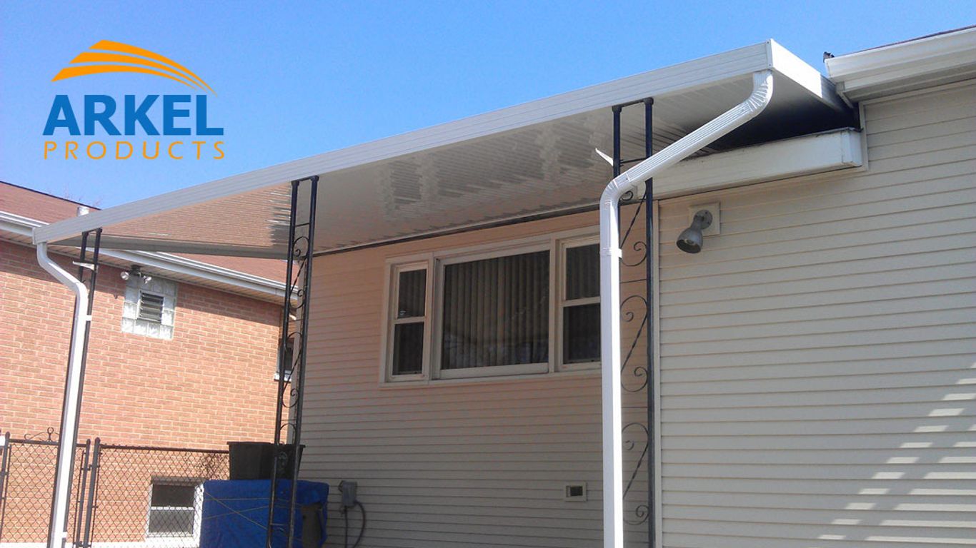 White awning over a house with a brick and siding exterior.