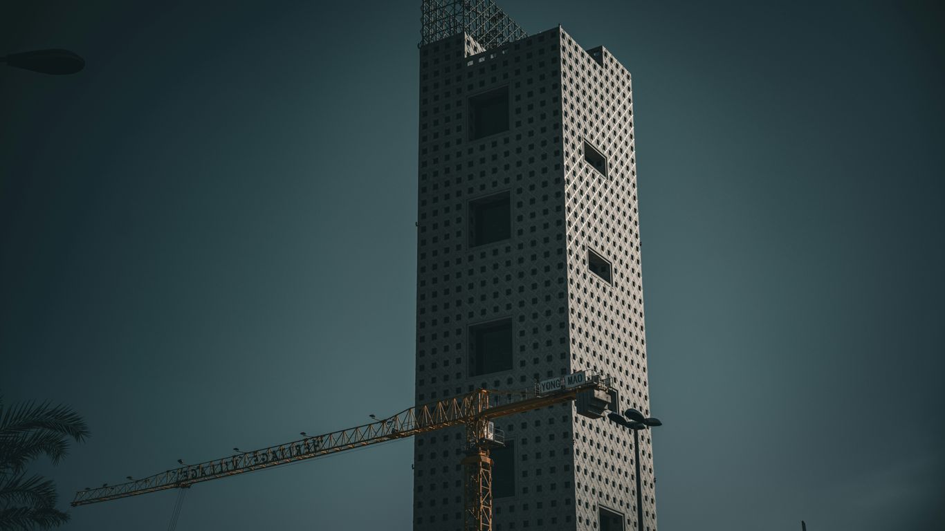 a tall building with a crane in front of it