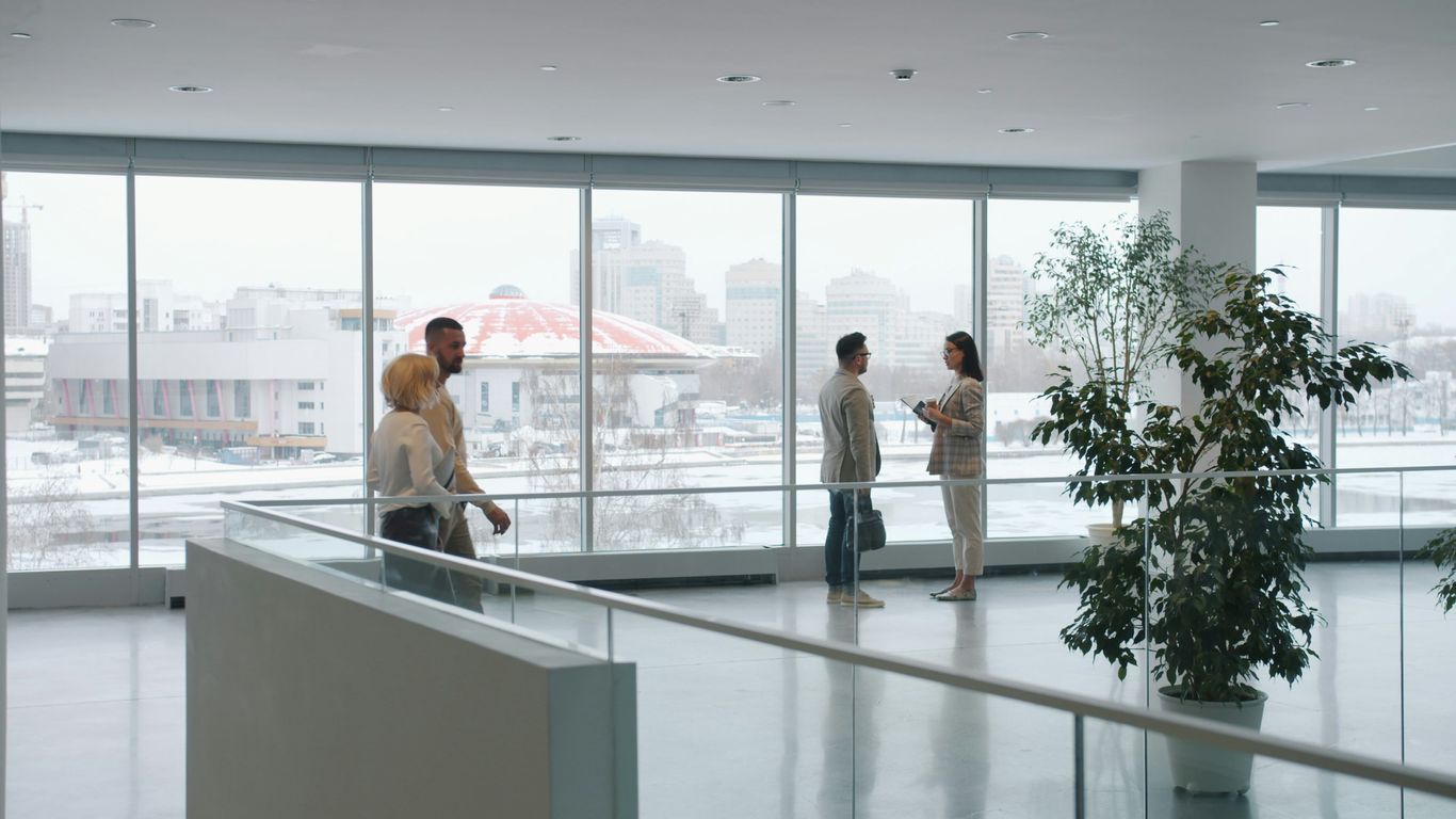 People in a modern office lobby with large windows
