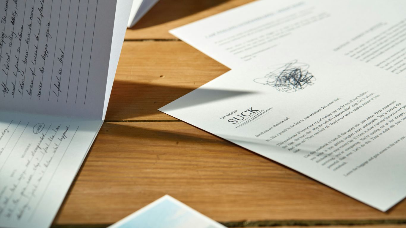 a pile of papers sitting on top of a wooden table