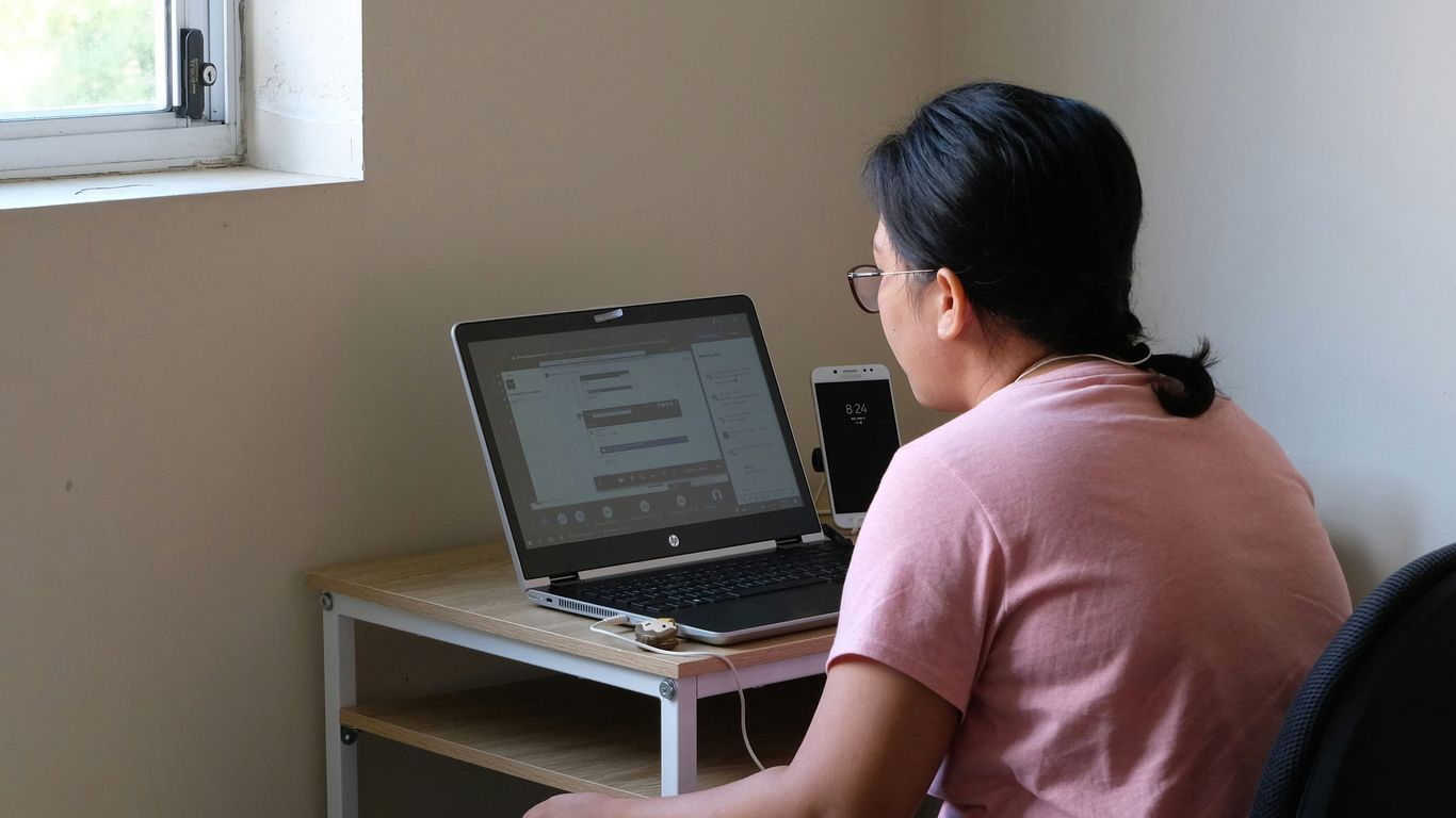woman in pink t-shirt using laptop computer