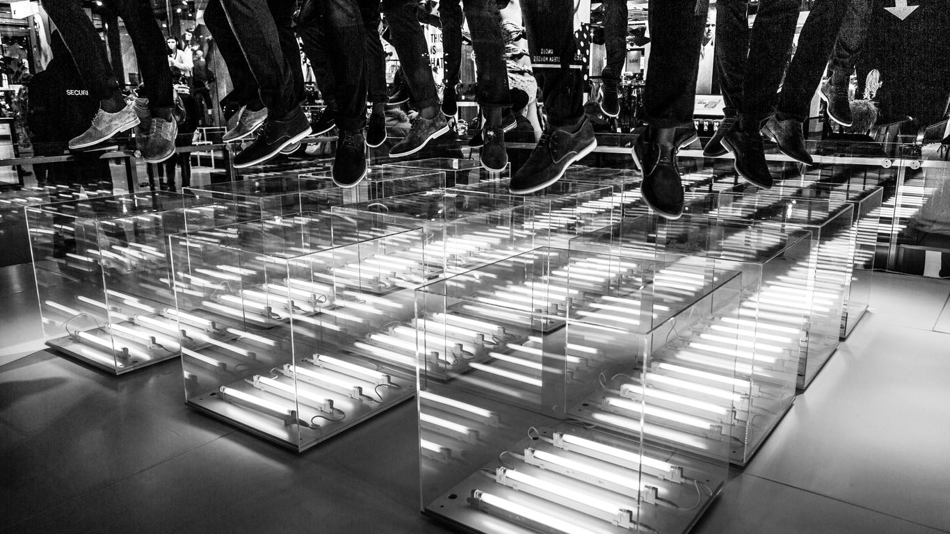 people in black pants and black shoes standing on black and white floor tiles