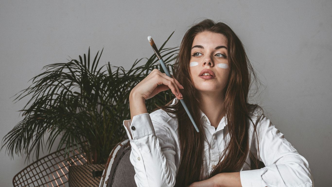 woman in white blazer holding pen