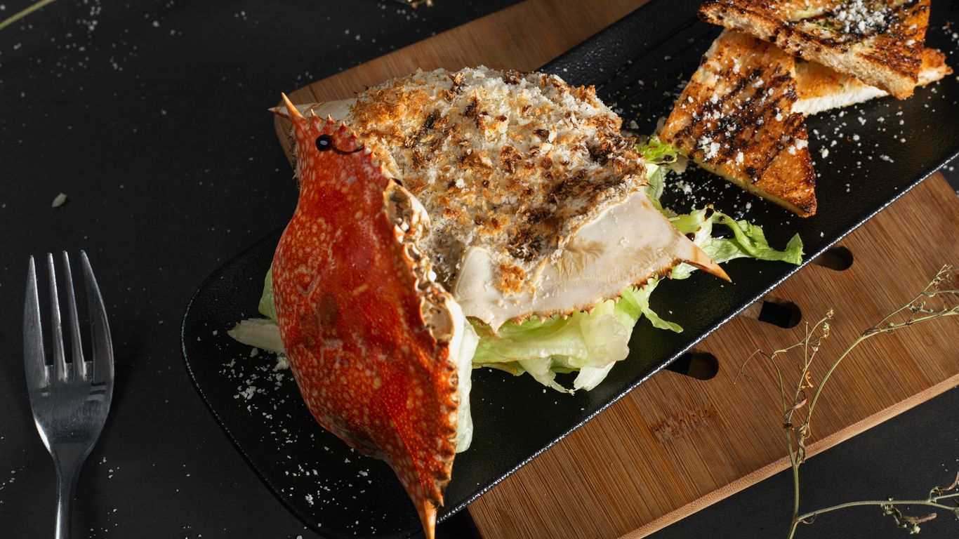 a black plate topped with a cut in half sandwich