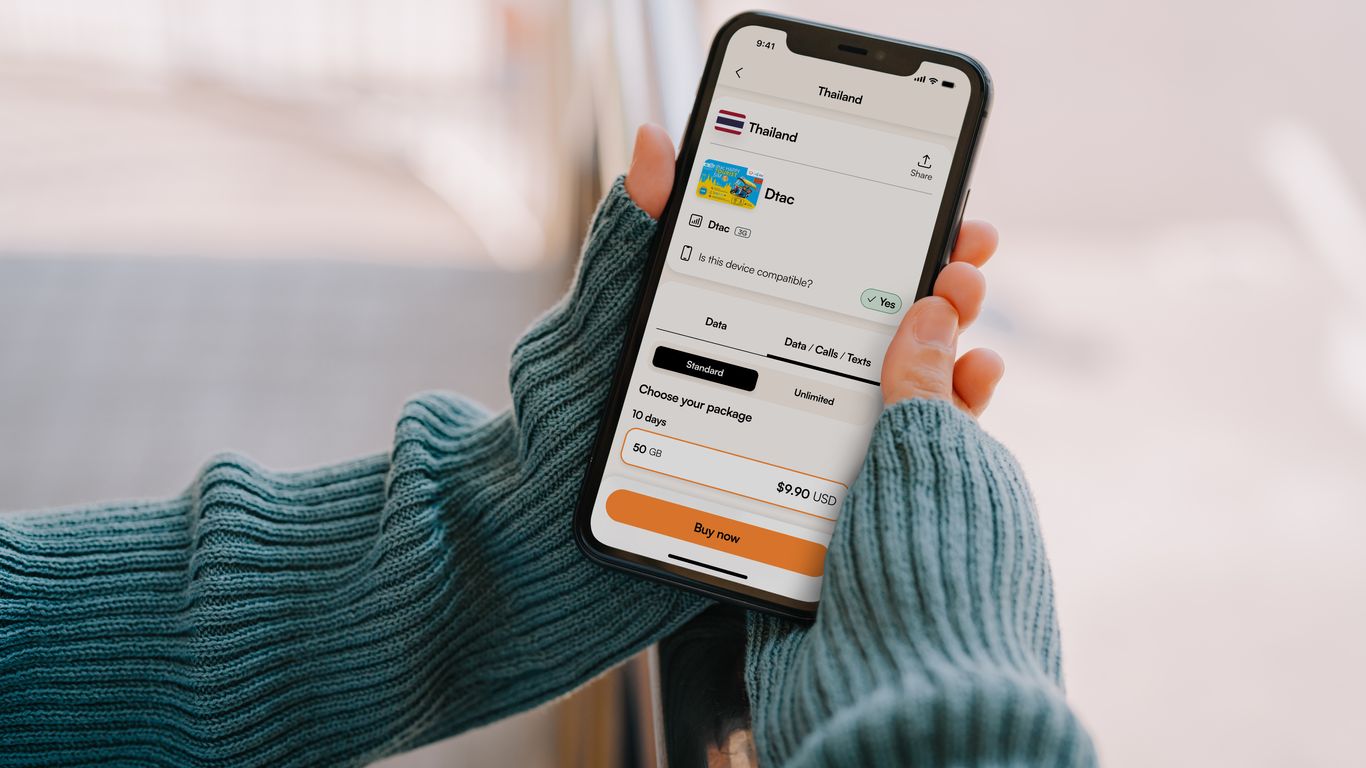 Person holding a smartphone with a travel app